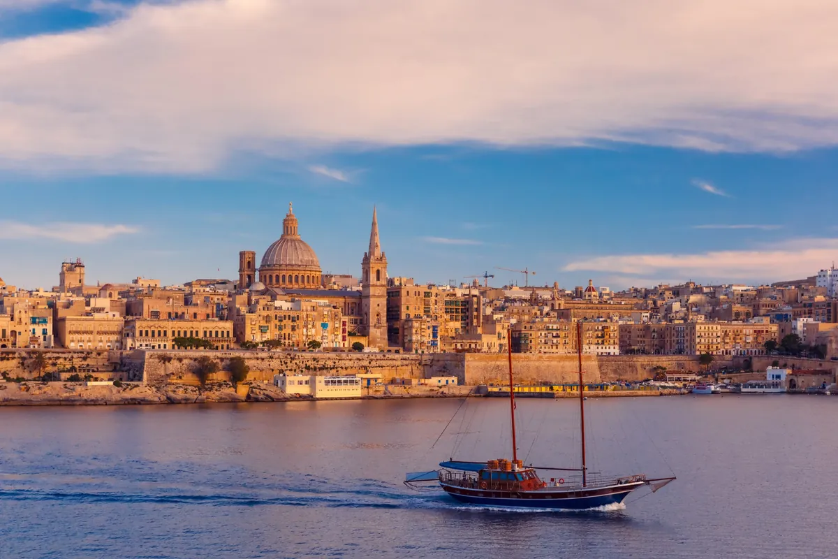 Spedire a Malta dall'Italia: skyline di La Valletta con la cupola della Basilica del Carmine e un veliero nel porto